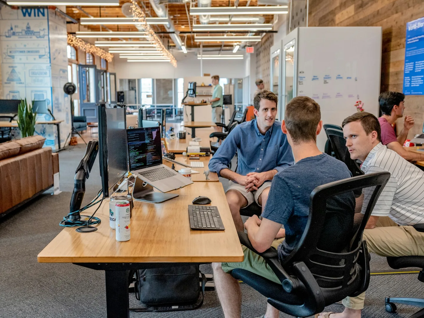 Colleagues discussing work around a desk.