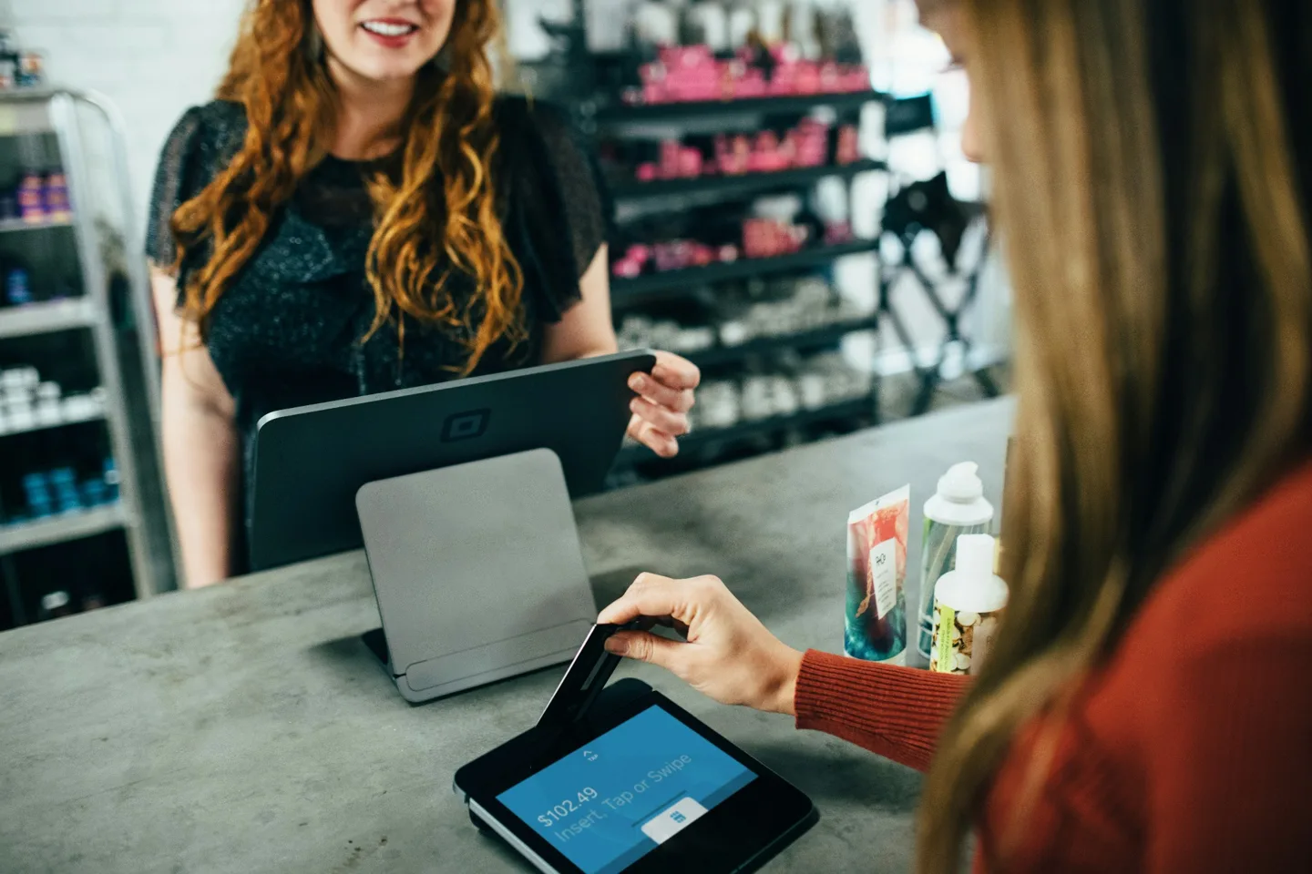 A customer completing a payment at a retail counter.